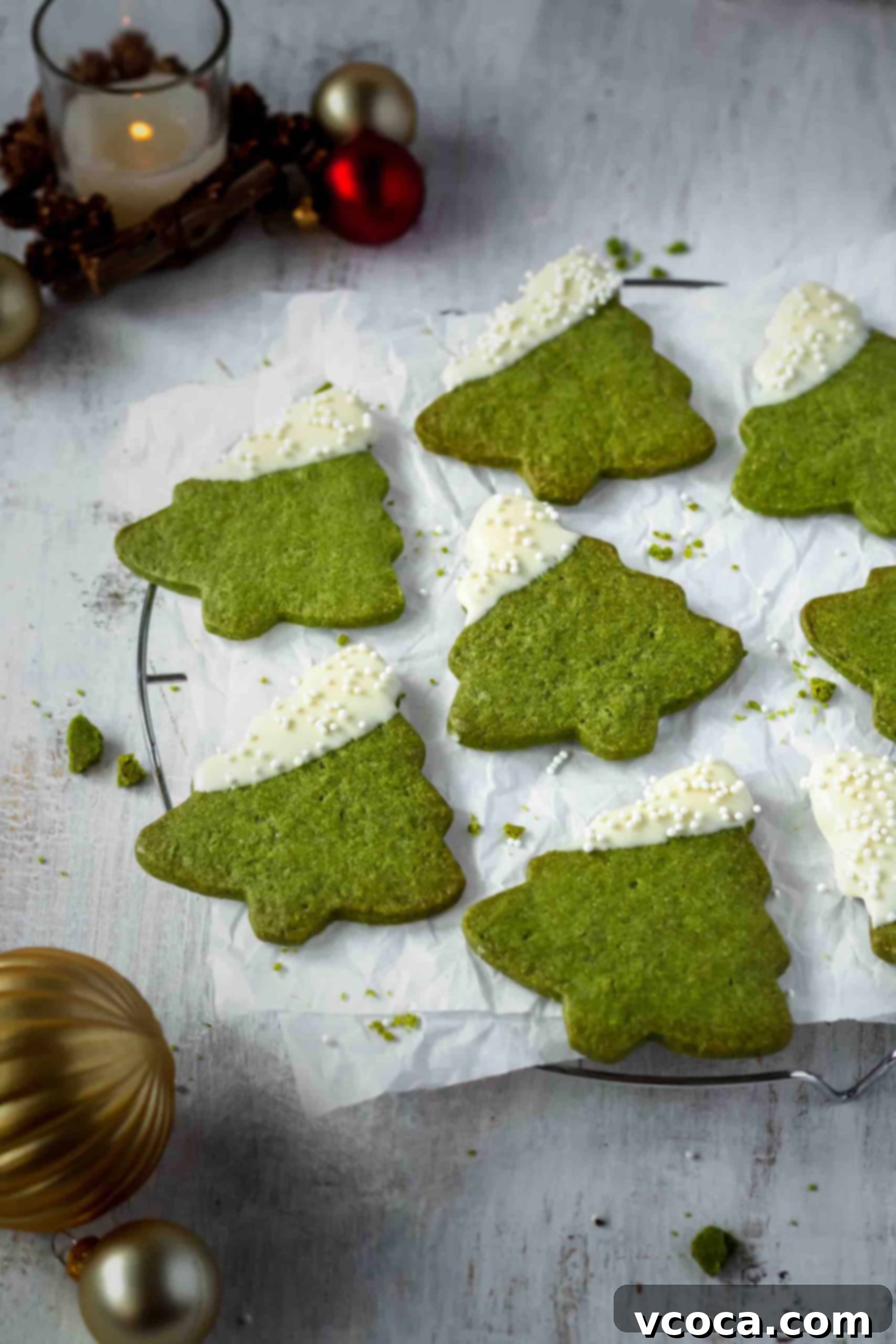 Festive Matcha Christmas Tree Cookies 5 A tray of decorated Matcha Christmas Tree Cookies cooling on a wire rack, featuring their vibrant green and elegant white chocolate dip, emphasizing quick and easy holiday cookie decorating.