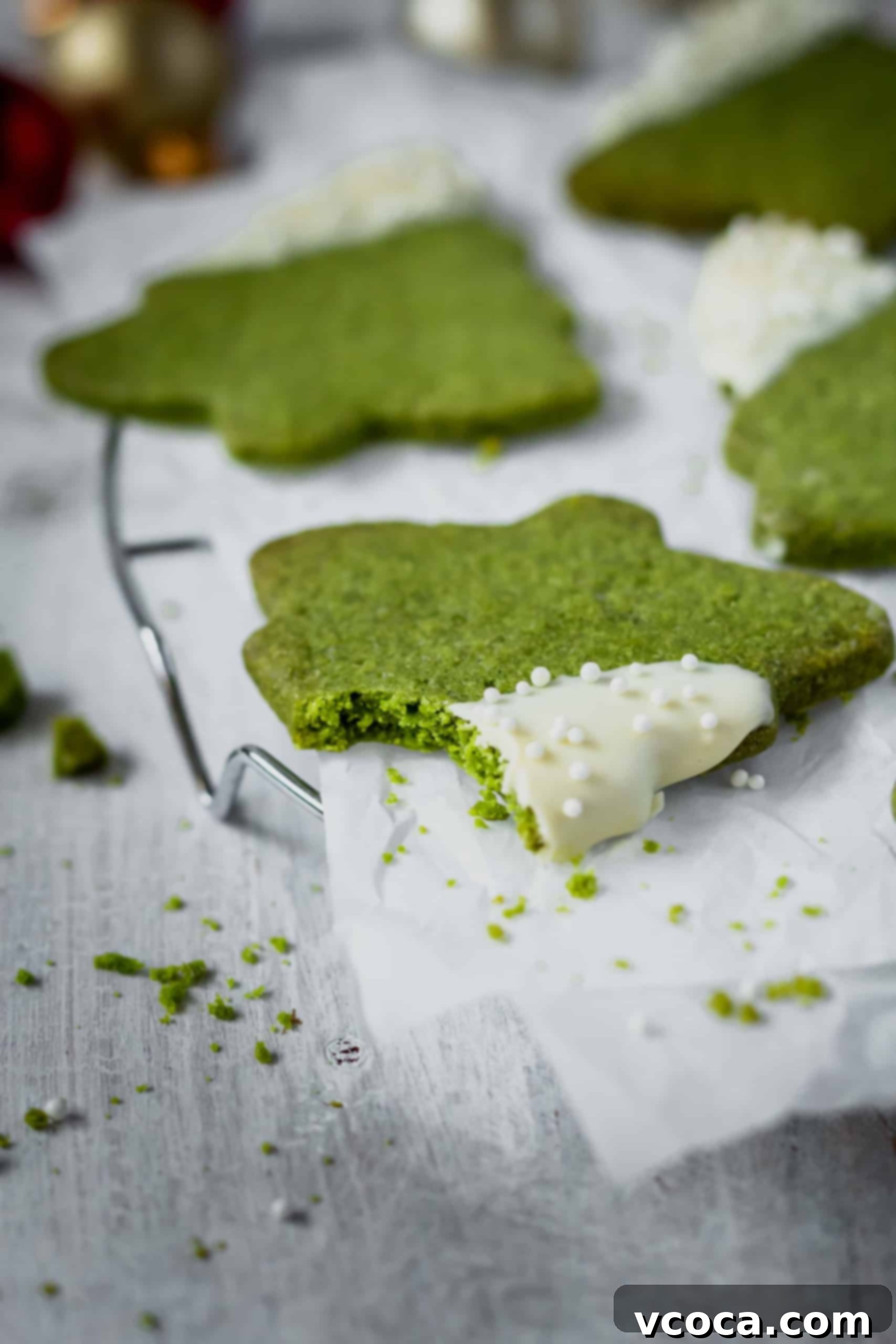 Festive Matcha Christmas Tree Cookies 6 Freshly baked Matcha Christmas Tree Cookies cooling on a wire rack, showcasing their crisp texture and natural green color, ready for festive decoration.