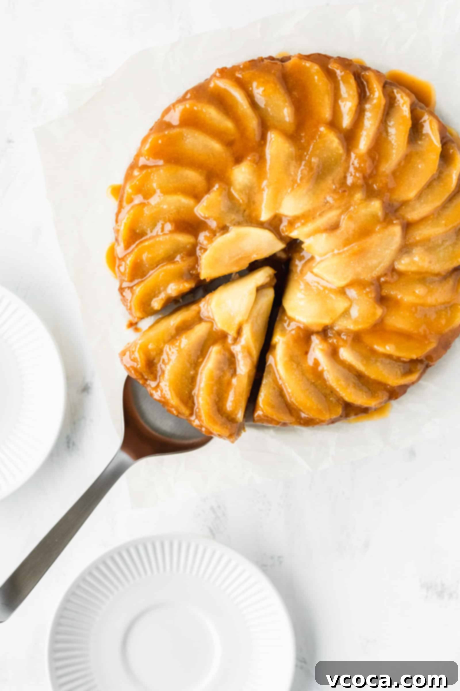 Pure Plant Apple Cake Bliss 5 Vegan apple upside-down cake with a slice cut out, revealing the soft texture and apple layers.