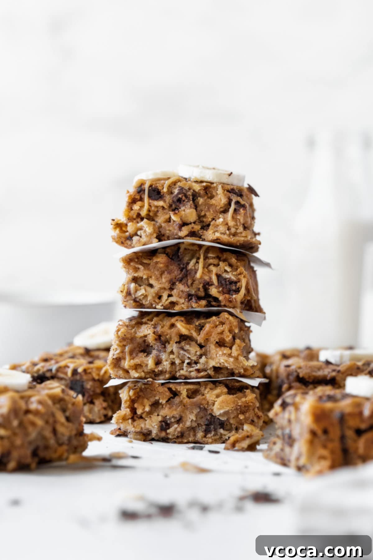 Gluten Free Peanut Butter Oatmeal Breakfast Bars 2 A side shot of a stack of peanut butter oatmeal breakfast bars on the counter with other bars in the background.