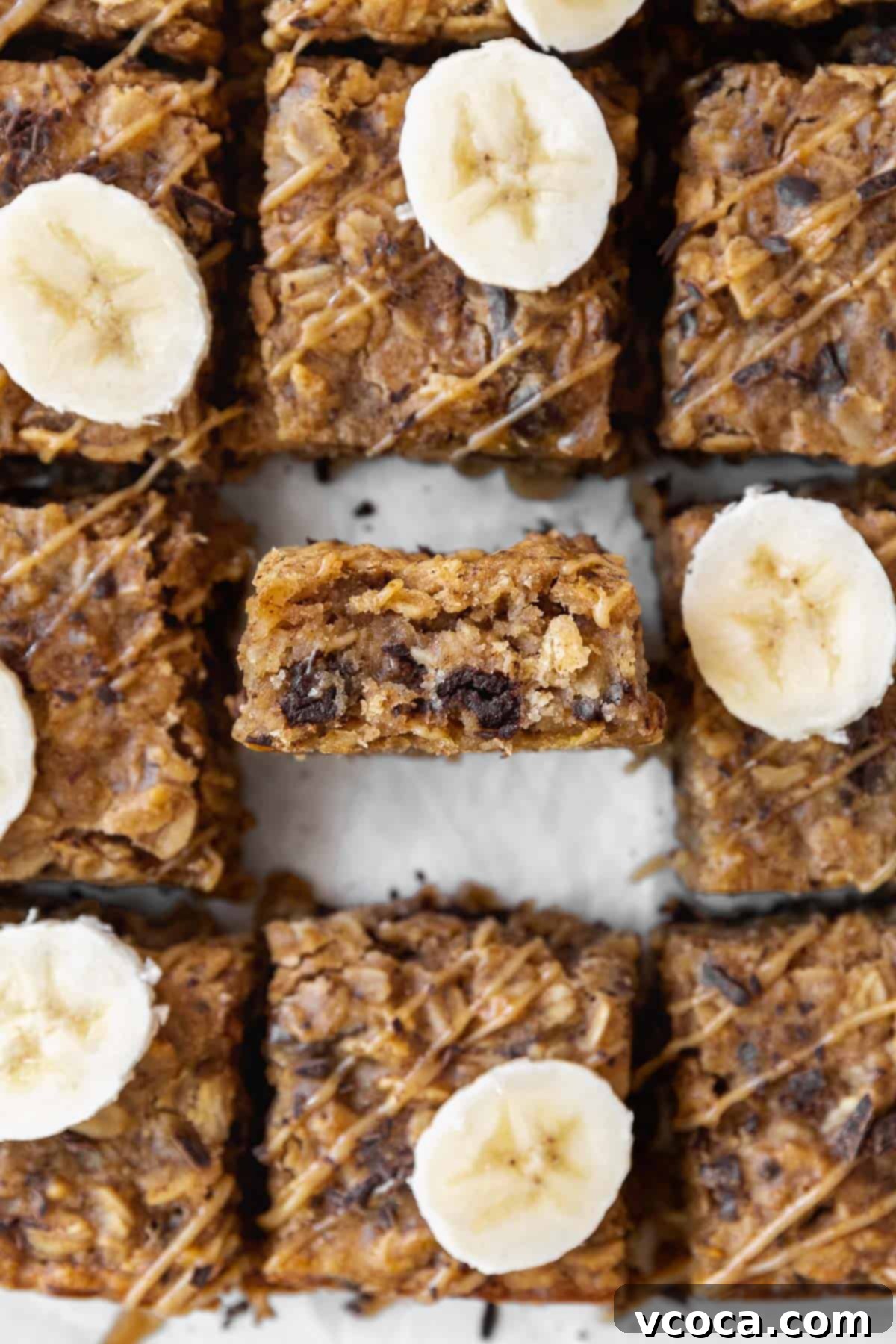 Gluten Free Peanut Butter Oatmeal Breakfast Bars 14 An overhead shot of peanut butter oatmeal bars on the counter with one bar in the center sitting on its side so you can see the inside.