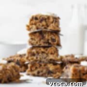 Gluten Free Peanut Butter Oatmeal Breakfast Bars 15 An up-close side shot of a stack of peanut butter banana oatmeal bars with other bars in the background.