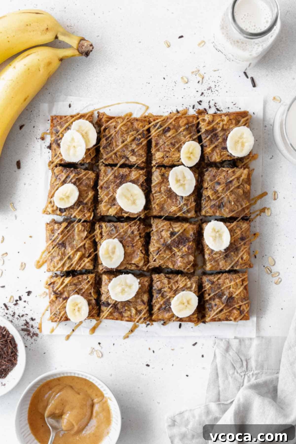 Gluten Free Peanut Butter Oatmeal Breakfast Bars 3 And overhead shot of pan of sliced peanut butter banana oatmeal bars on a piece of parchment paper.
