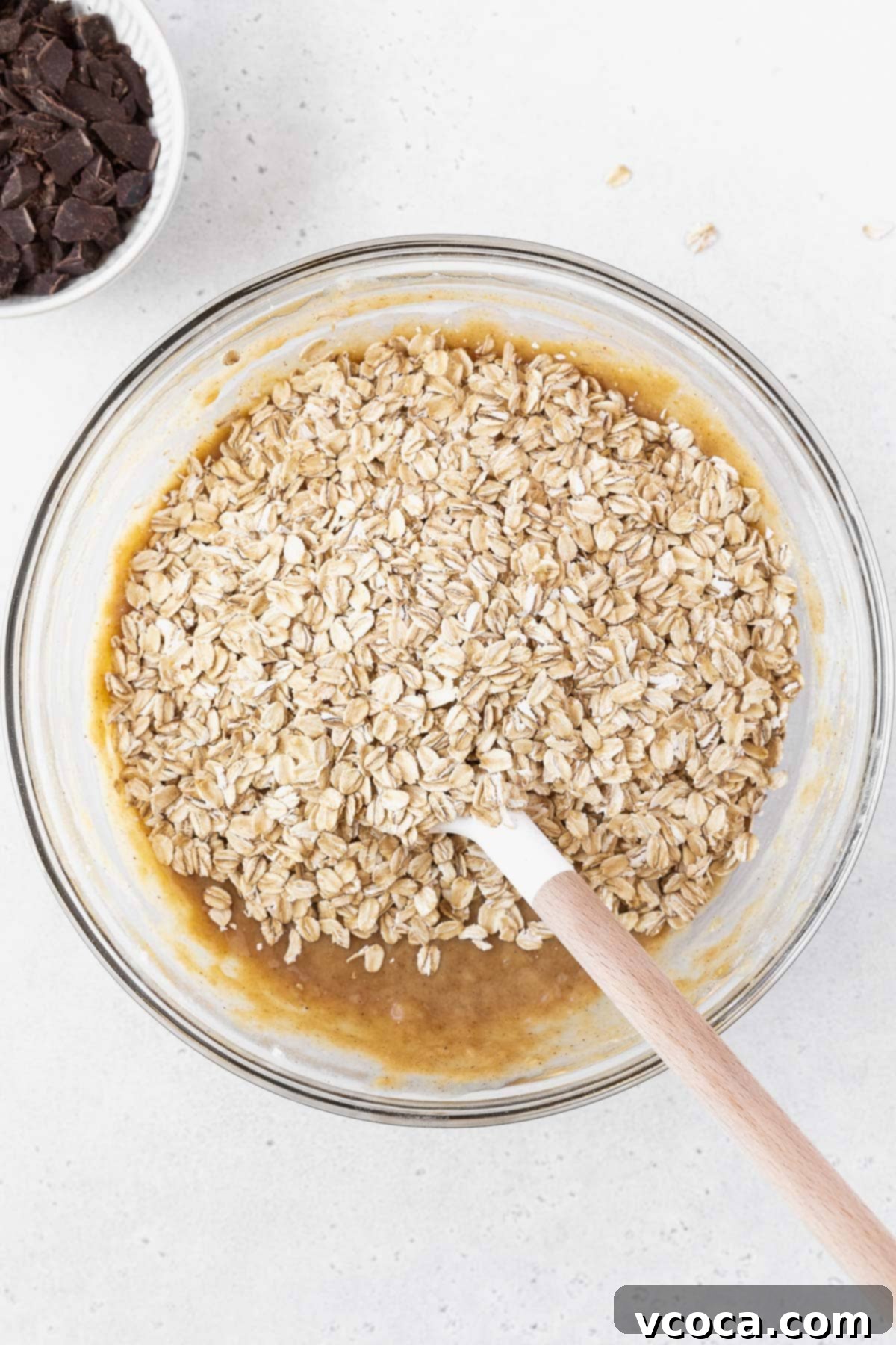 Gluten Free Peanut Butter Oatmeal Breakfast Bars 9 A mixing bowl of peanut butter banana bars with oatmeal on top.