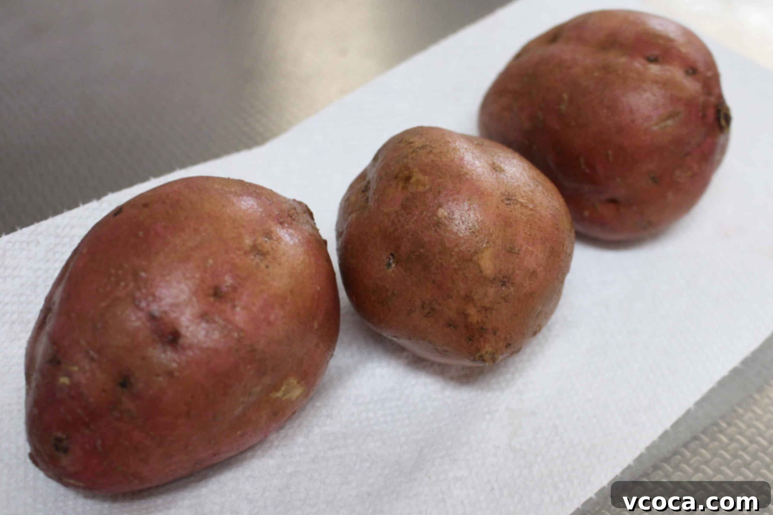 Caramelized Japanese Sweet Potatoes 3 Freshly washed Japanese sweet potatoes with reddish-purple skin.