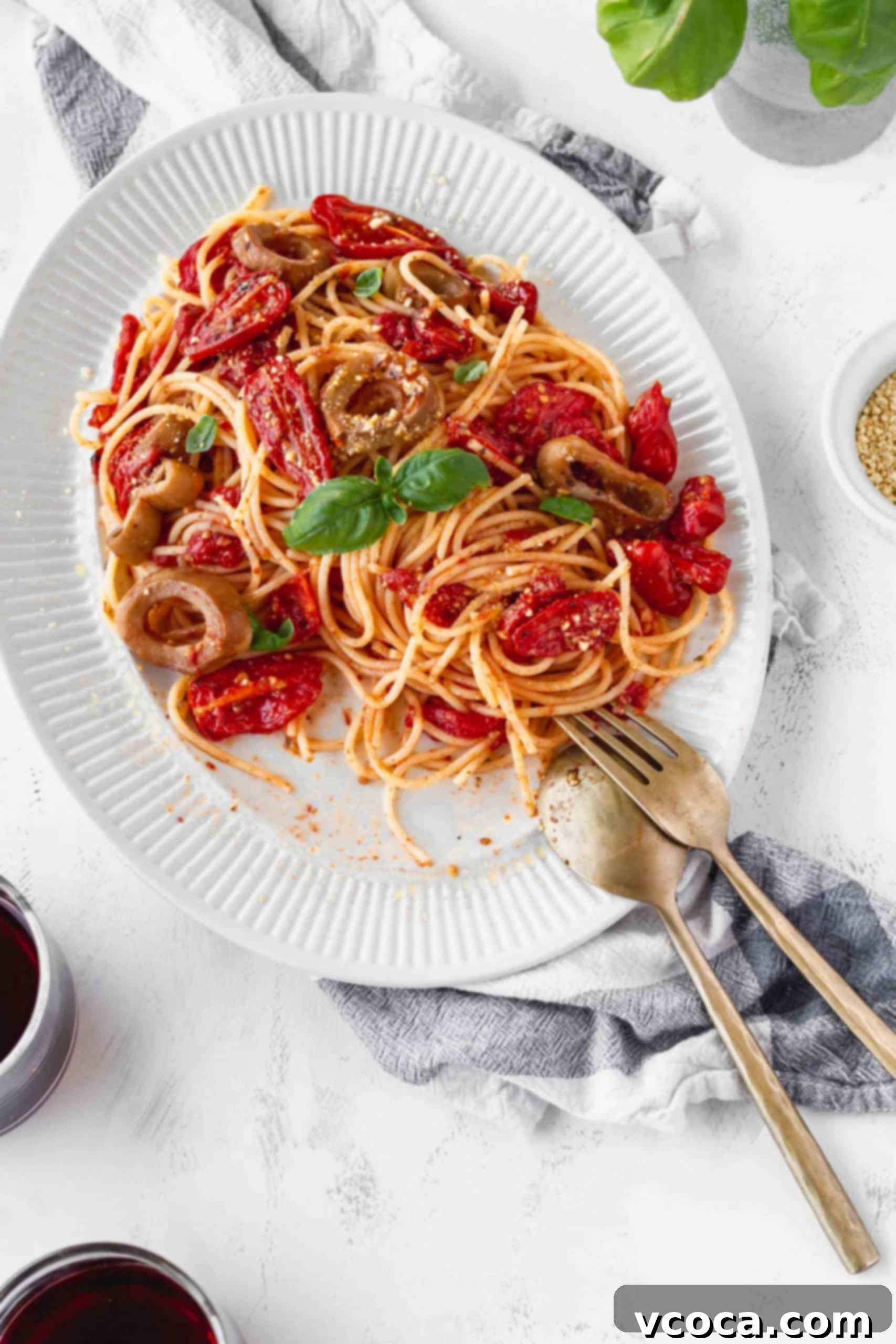 Sun-Drenched Tomato Pasta with Crispy Vegan Calamari 3 A close-up of a plate of spaghetti with vibrant cherry tomato sauce, ready to be served.