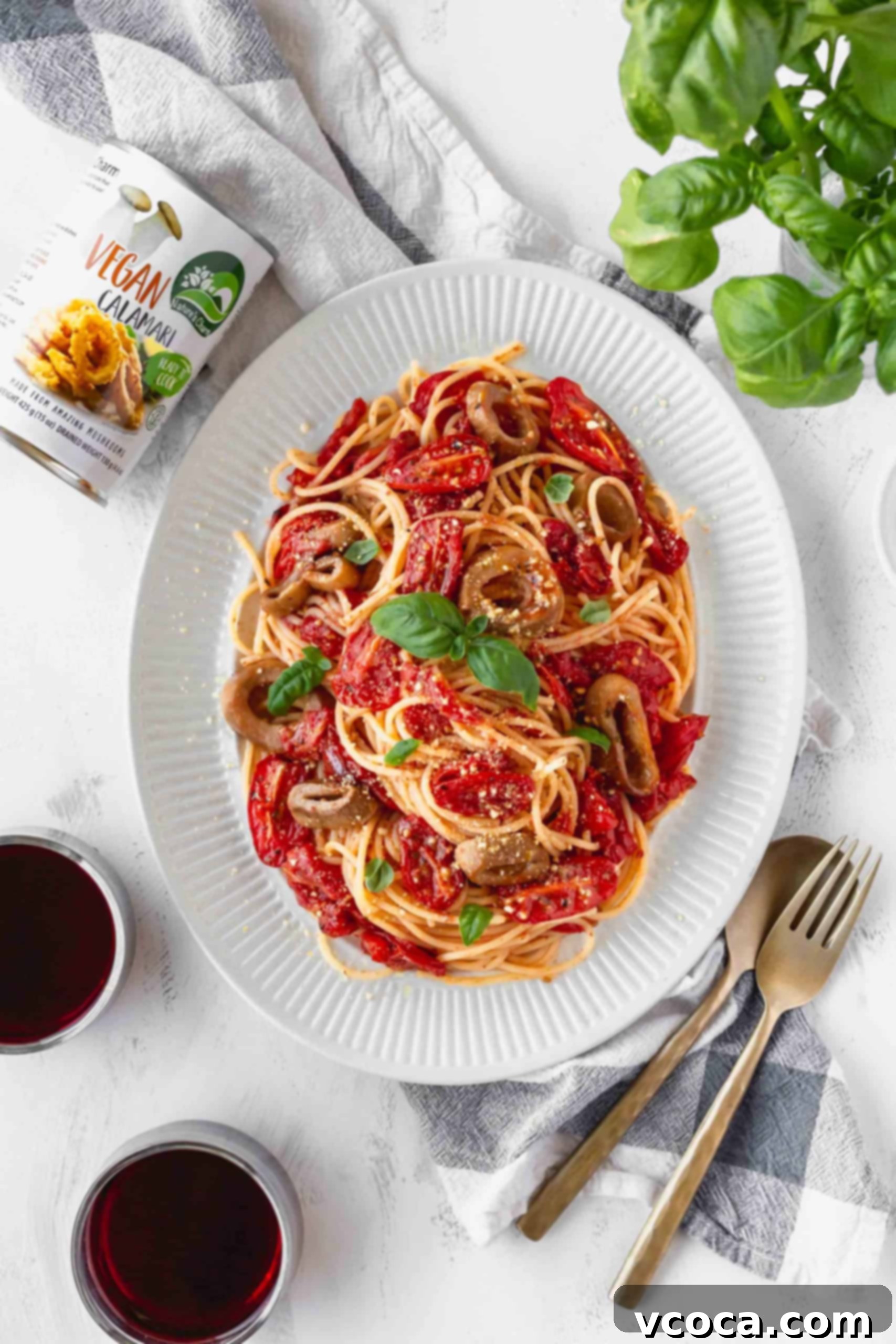 Sun-Drenched Tomato Pasta with Crispy Vegan Calamari 6 A plate of vegan and gluten-free spaghetti with roasted cherry tomato sauce and a can of Nature's Charm vegan calamari on the side, highlighting the key ingredients.