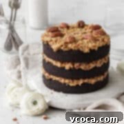 Decadent Gluten-Free German Chocolate Dream 16 Gluten-free German chocolate cake on a round white board on a neutral linen.