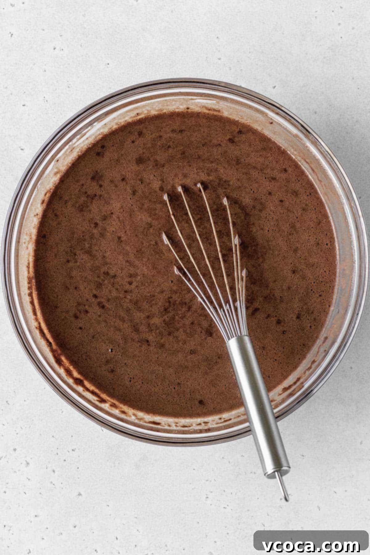 Decadent Gluten-Free German Chocolate Dream 8 Gluten-free German chocolate cake batter in a glass bowl with a whisk inside.