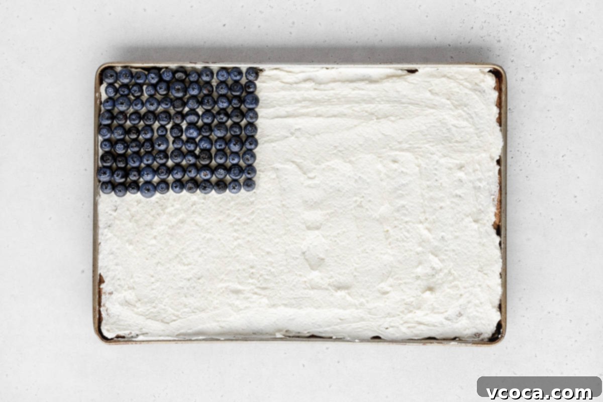Festive 4th of July Fruit Pizza 11 Blueberries carefully added to the upper-left quadrant of the sheet pan cookie base, representing the stars portion of the American flag design.