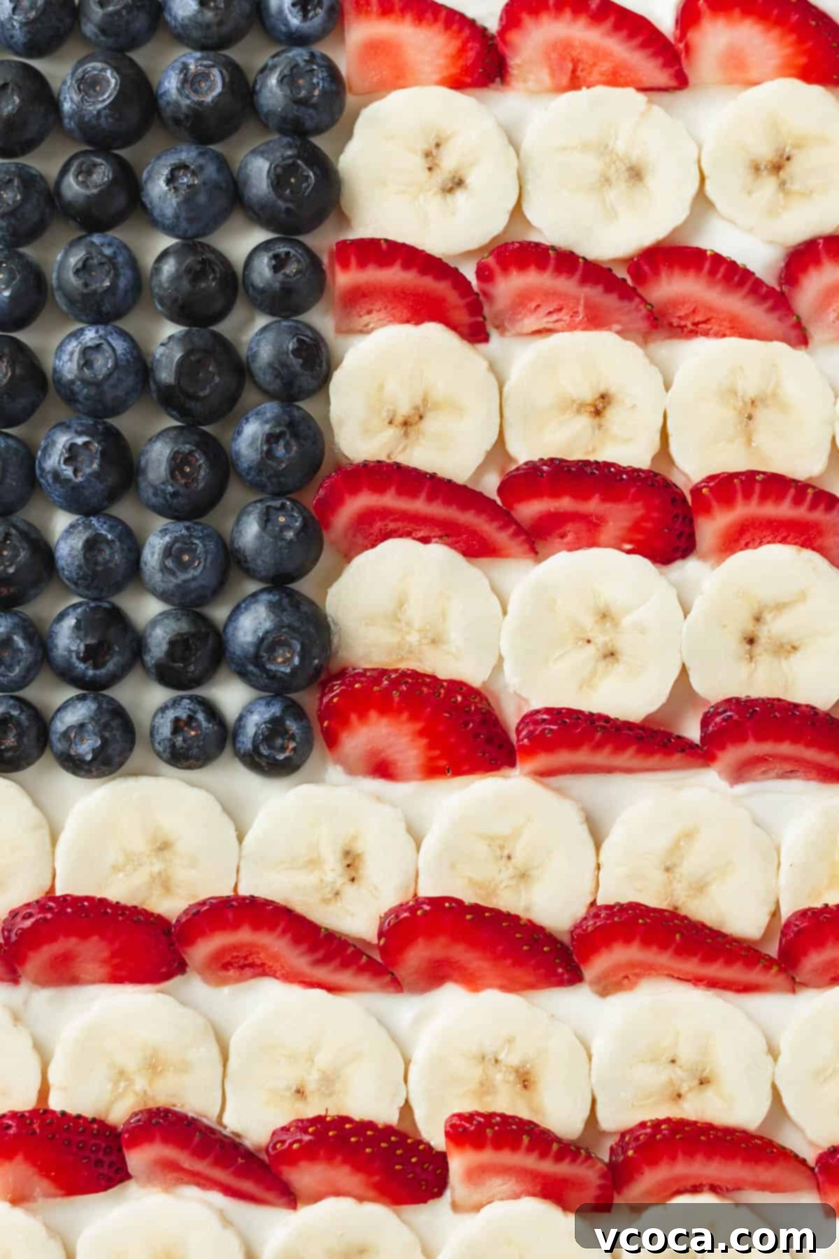Festive 4th of July Fruit Pizza 3 Blueberries, sliced bananas, and sliced strawberries arranged in the iconic American flag pattern on a sugar cookie "pizza" base.