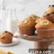 Irresistible Gluten-Free Banana Muffins 6 Gluten-free banana muffins on a wooden cake stand.
