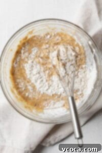 Dry ingredients being whisked into wet ingredients.