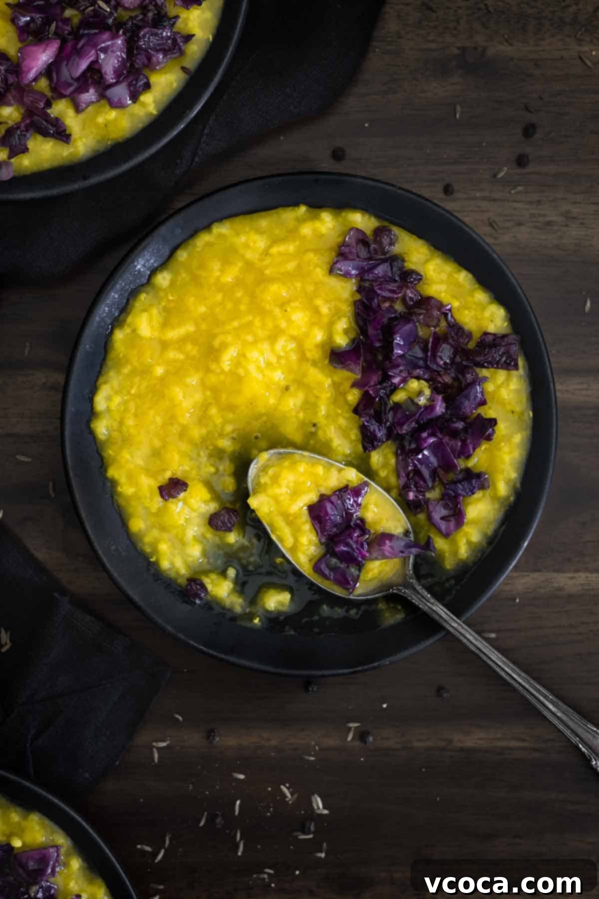 Hearty Cabbage and Onion Khichdi 5 A perfectly portioned bowl of creamy Indian Khichdi, a comforting rice and lentil porridge, accompanied by a spoon, ready to be enjoyed.