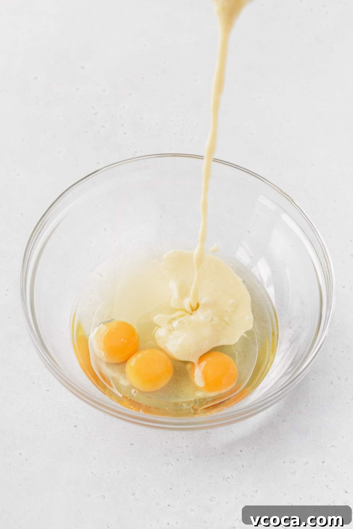 Golden Gluten Free Cornbread 7 Corn and milk mixture being poured into eggs and oil, forming the wet ingredients for gluten-free cornbread.