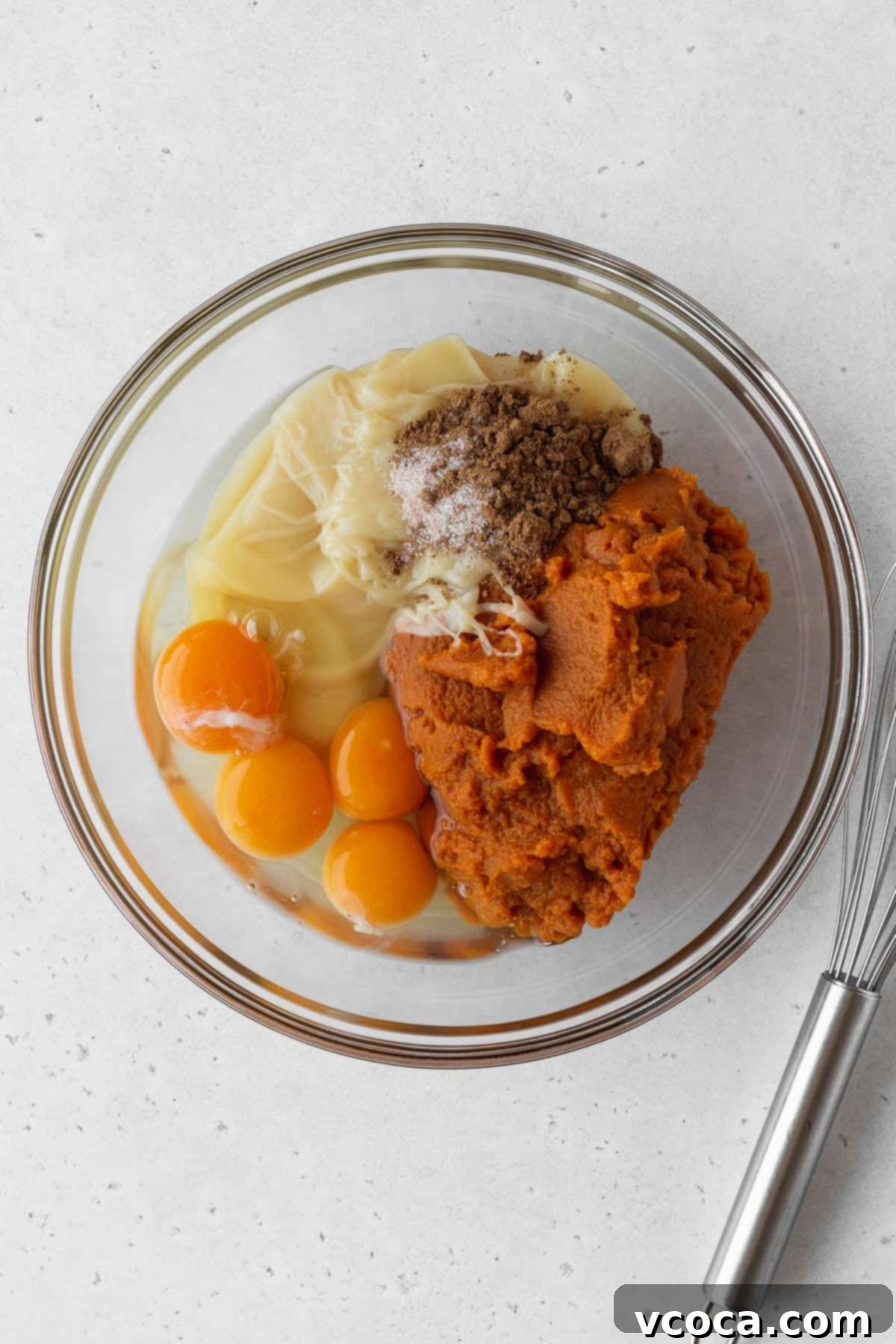 Wholesome Vegan Pumpkin Perfection 13 Pumpkin purée, eggs, vegan sweetened condensed milk, salt, and pumpkin pie spice in a glass bowl.