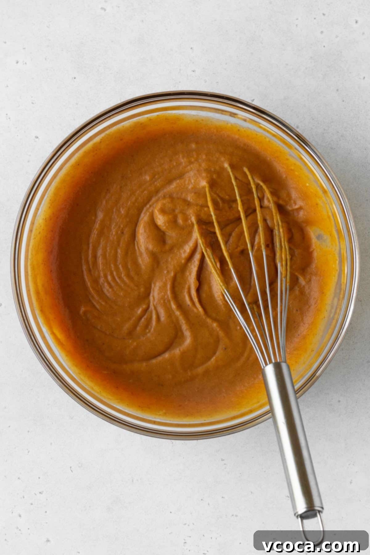 Wholesome Vegan Pumpkin Perfection 14 Pumpkin pie filling ingredients mixed together in a bowl with a whisk.