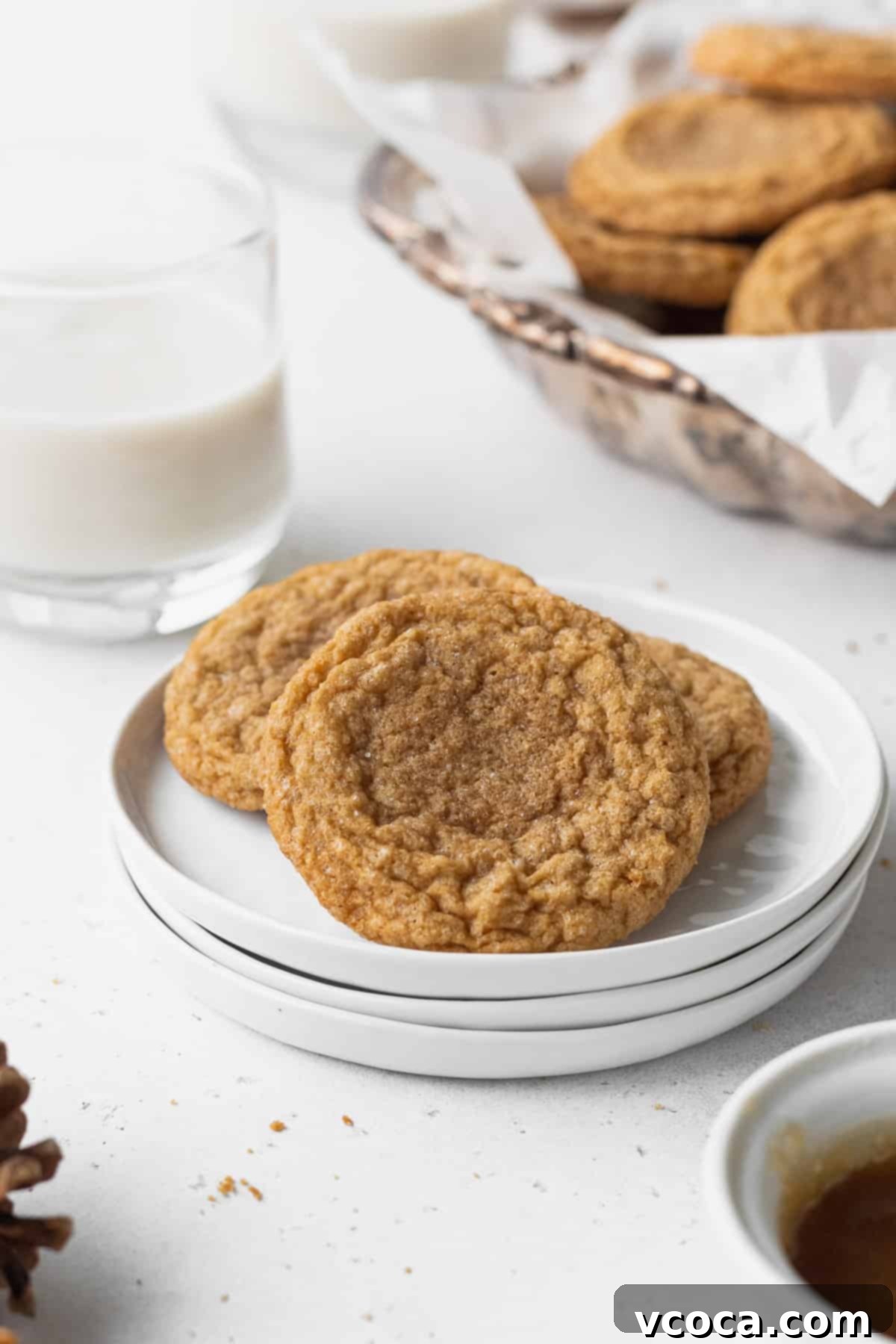 Heavenly Chewy Gluten-Free Ginger Cookies 15 A trio of gluten-free ginger cookies elegantly presented on a stack of white plates, ready for a festive gathering.