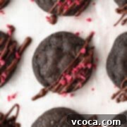 A close up shot of double chocolate chip cookies with freeze-dried raspberries sprinkled on top.
