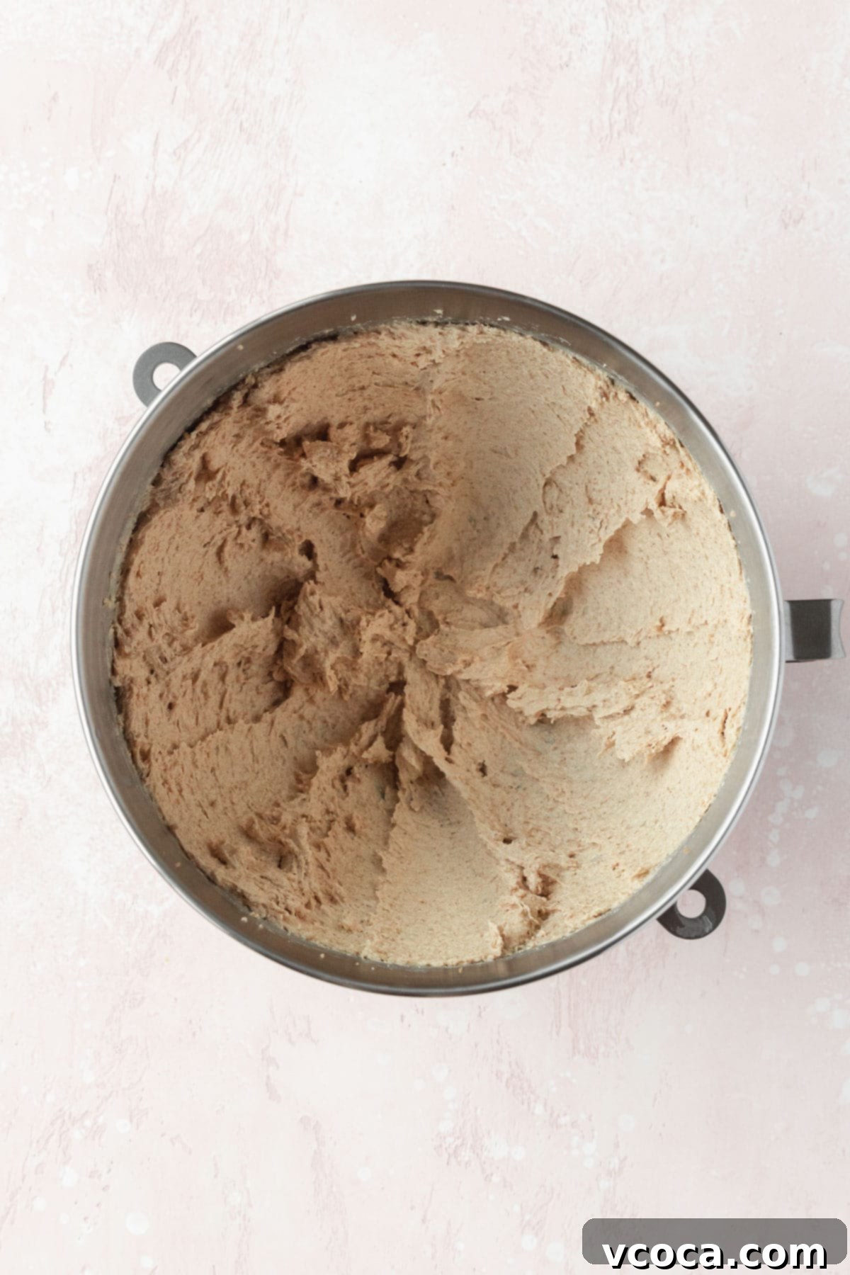 Butter, coconut oil, and sugar that has been creamed in a silver bowl. The mixture is light and fluffy.