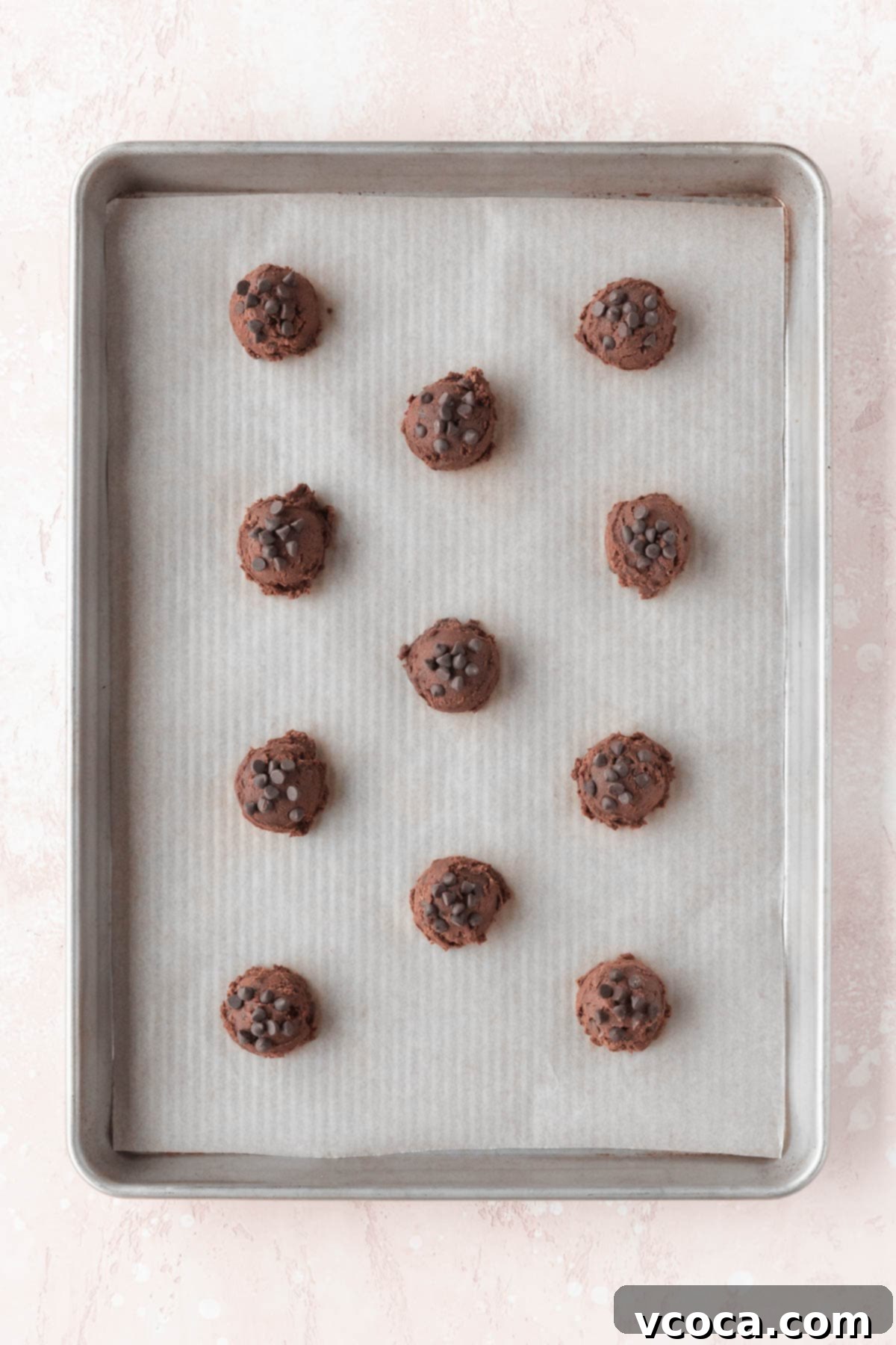 Chocolate cookie dough laid out on a baking sheet, ready for baking.