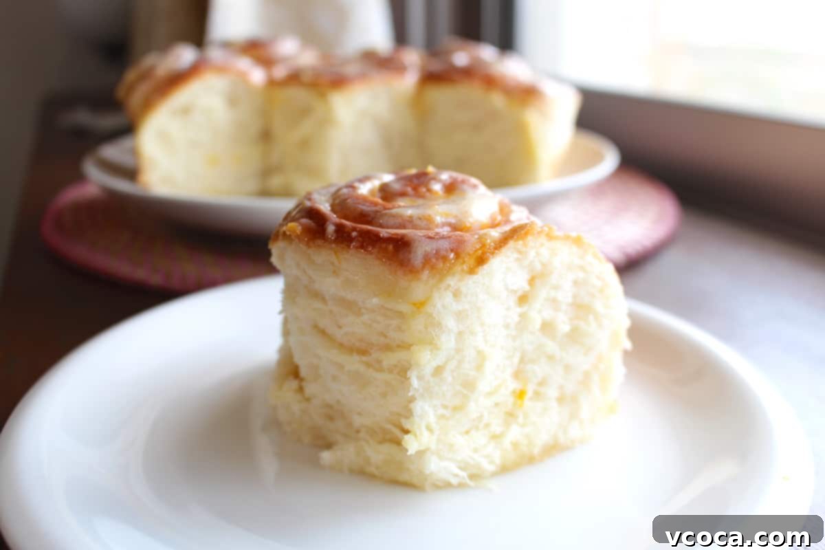 Zesty Lemon Rolls 8 A straight on shot of a fluffy lemon sweet roll on a plate, highlighting its soft texture and inviting frosting.