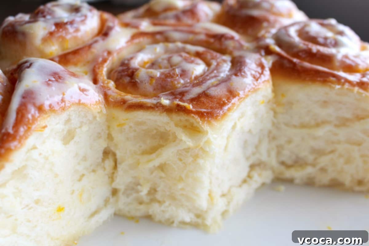 Zesty Lemon Rolls 9 45 degree angle shot of fluffy iced lemon rolls in a round pan, inviting a bite.