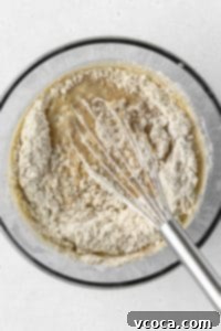 Dry ingredients being whisked into wet ingredients.