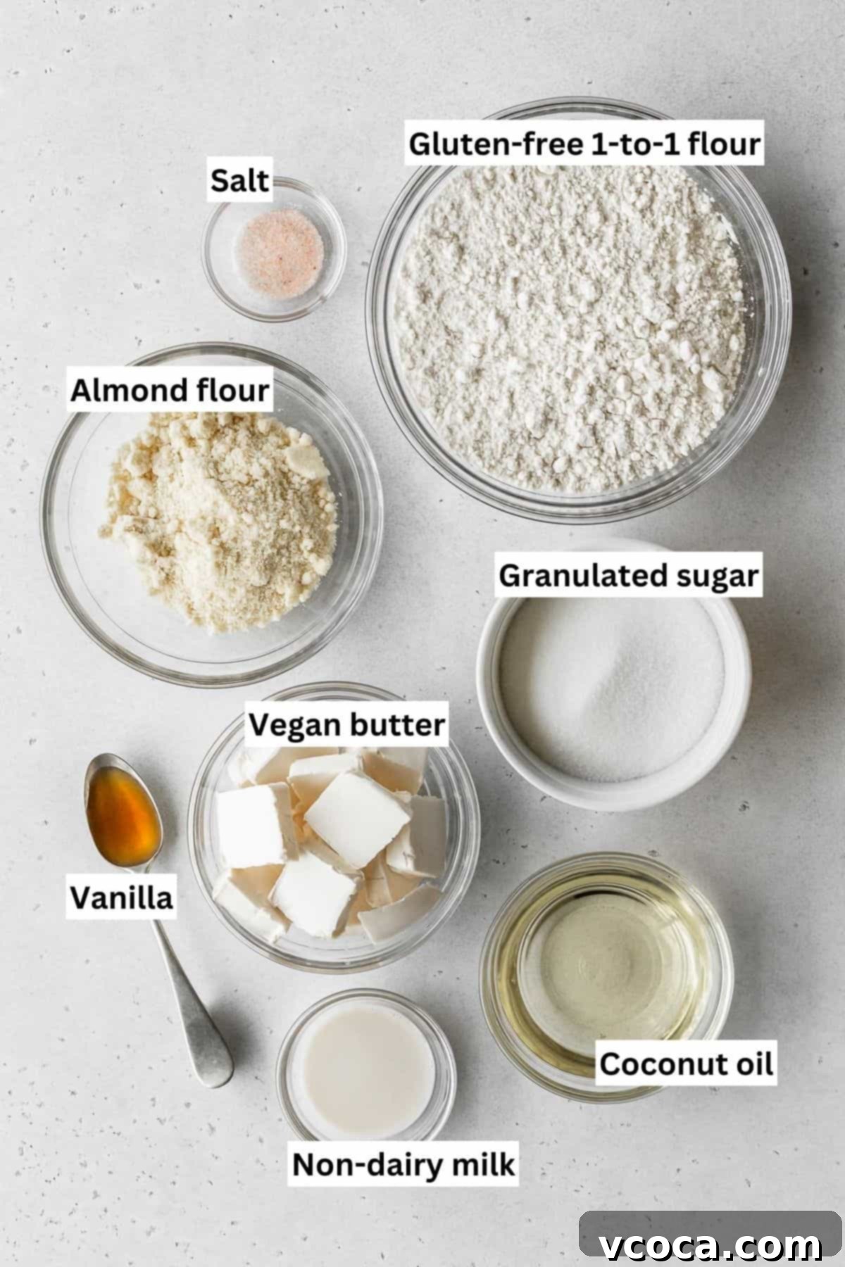 Joyful Easter Cookie Delights 3 Easter egg sugar cookie ingredients measured out into bowls, including flours, sugar, and vegan butter.