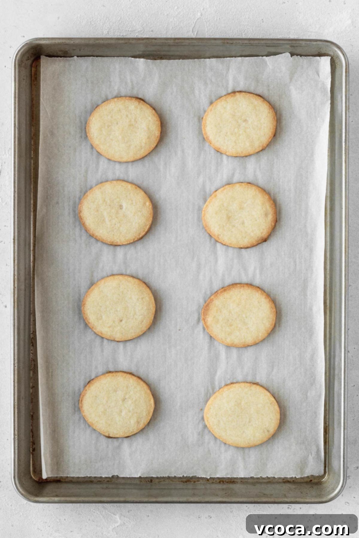Joyful Easter Cookie Delights 9 Baked egg shaped cookies on a baking sheet, golden brown and cooled.