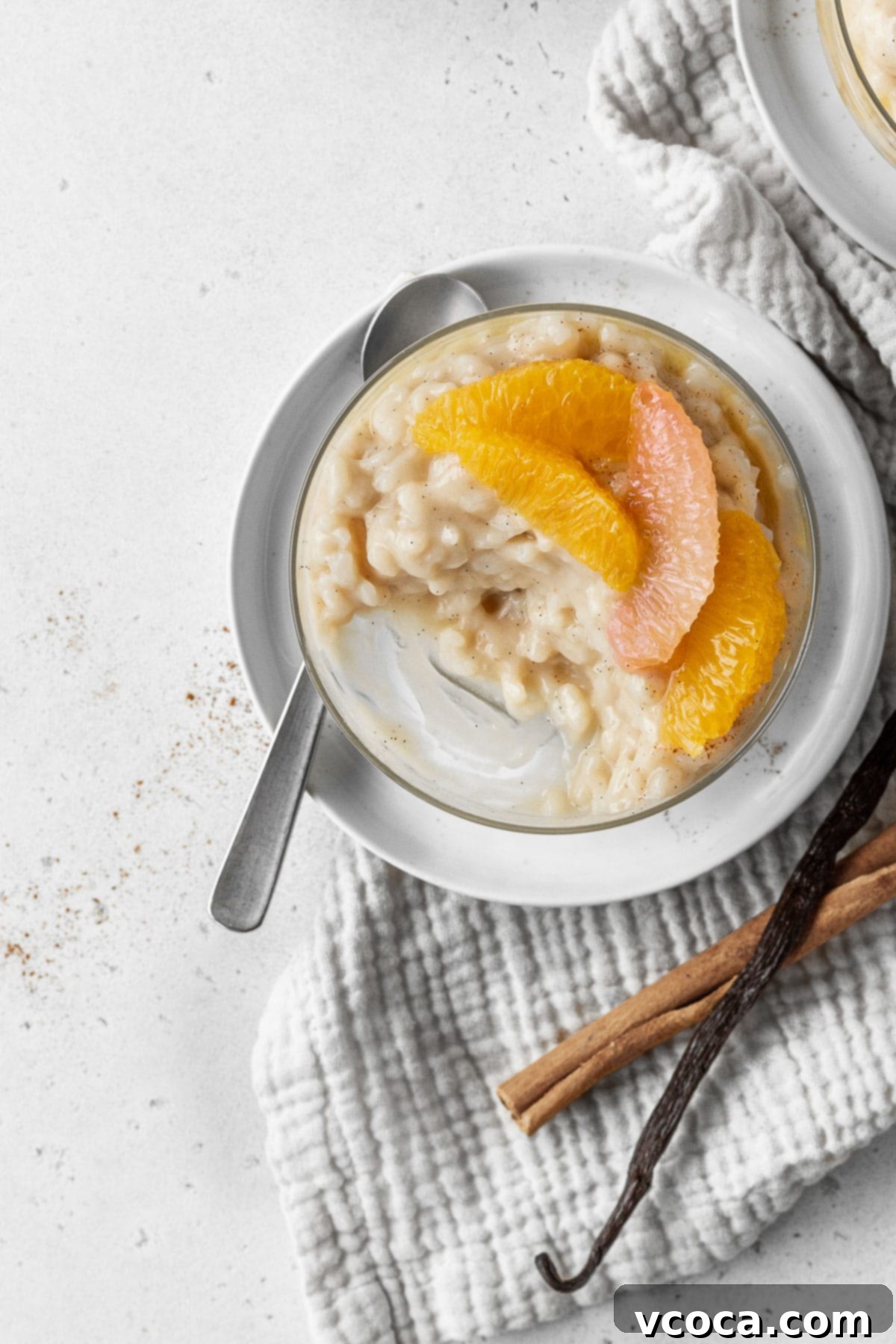 Dreamy Vegan Rice Pudding 12 A half eaten glass of vegan rice pudding with citrus segments on top.