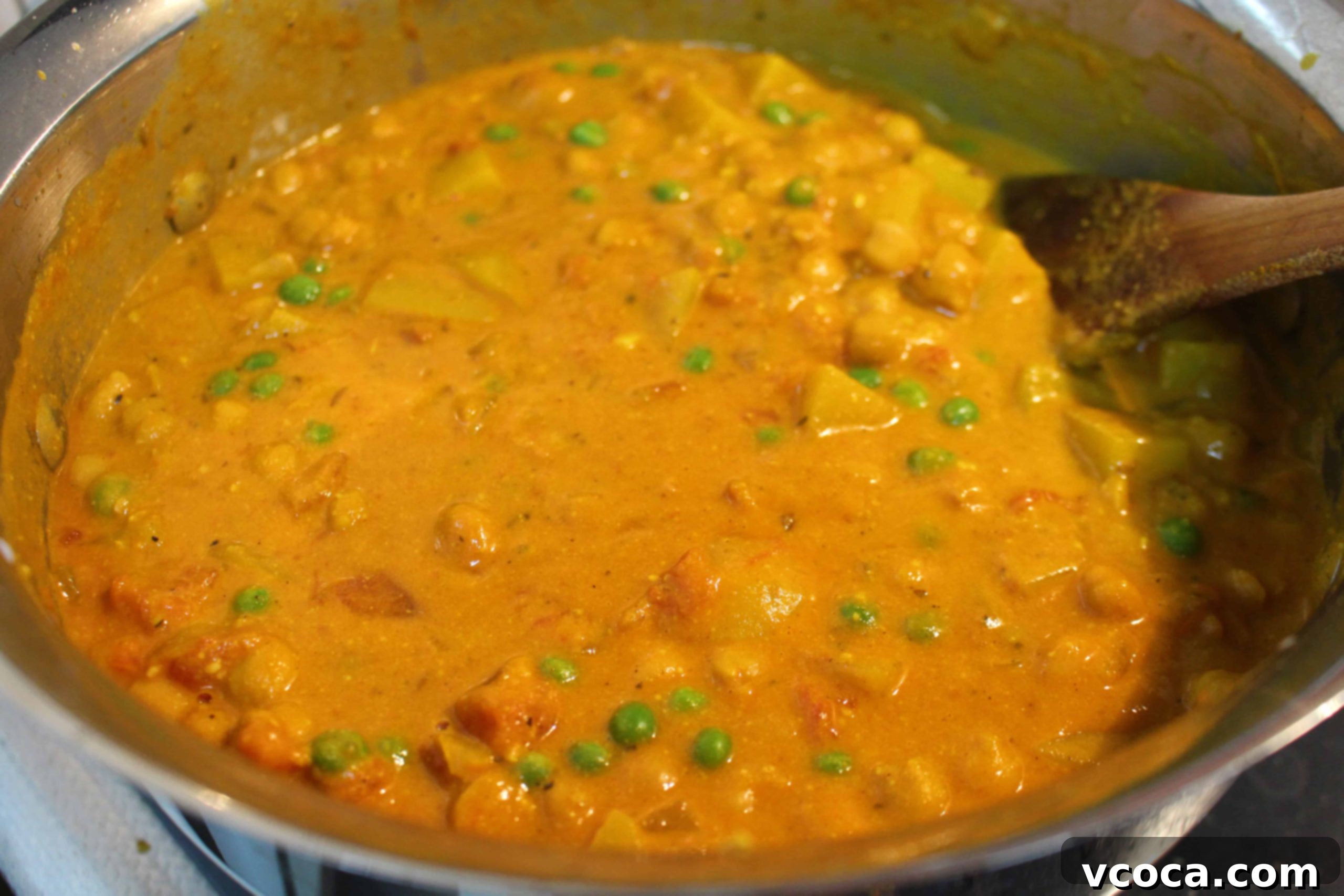 Spicy Jerk Chicken and Hearty Chickpea Curry 5 A pot on the stove with diced onions and various spices being cooked, forming the aromatic base for the chickpea curry.