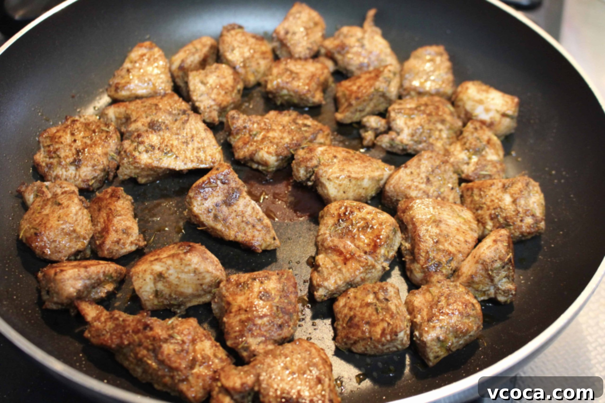 Spicy Jerk Chicken and Hearty Chickpea Curry 7 Golden-brown jerk chicken pieces sizzling in a nonstick pan over medium heat, showing the perfect sear and marinade.