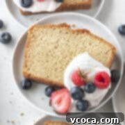 Indulgent Gluten-Free Pound Cake 16 A slice of gluten-free pound cake on a plate with whipped cream and berries.