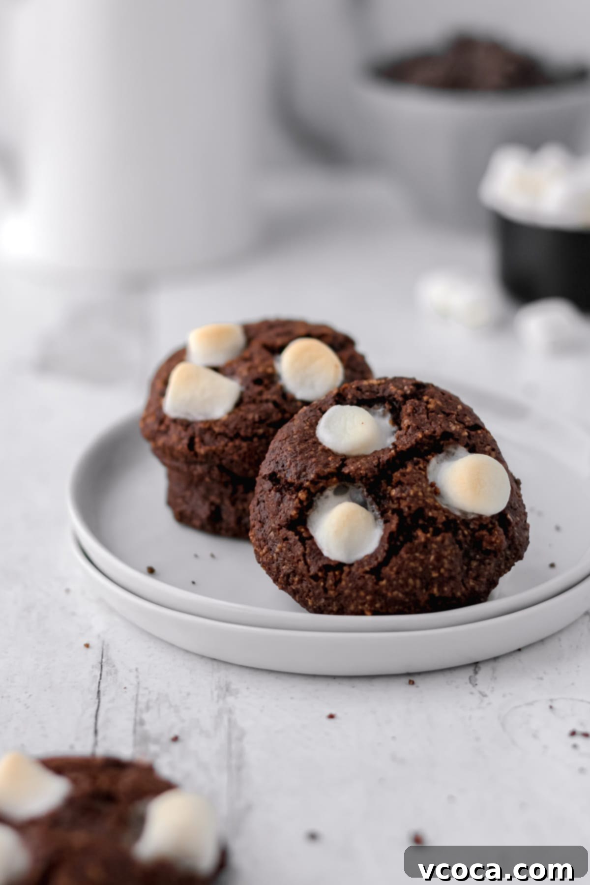 Irresistible Gluten-Free Christmas Treats 10 Hot cocoa cookies on a stack of small white plates.
