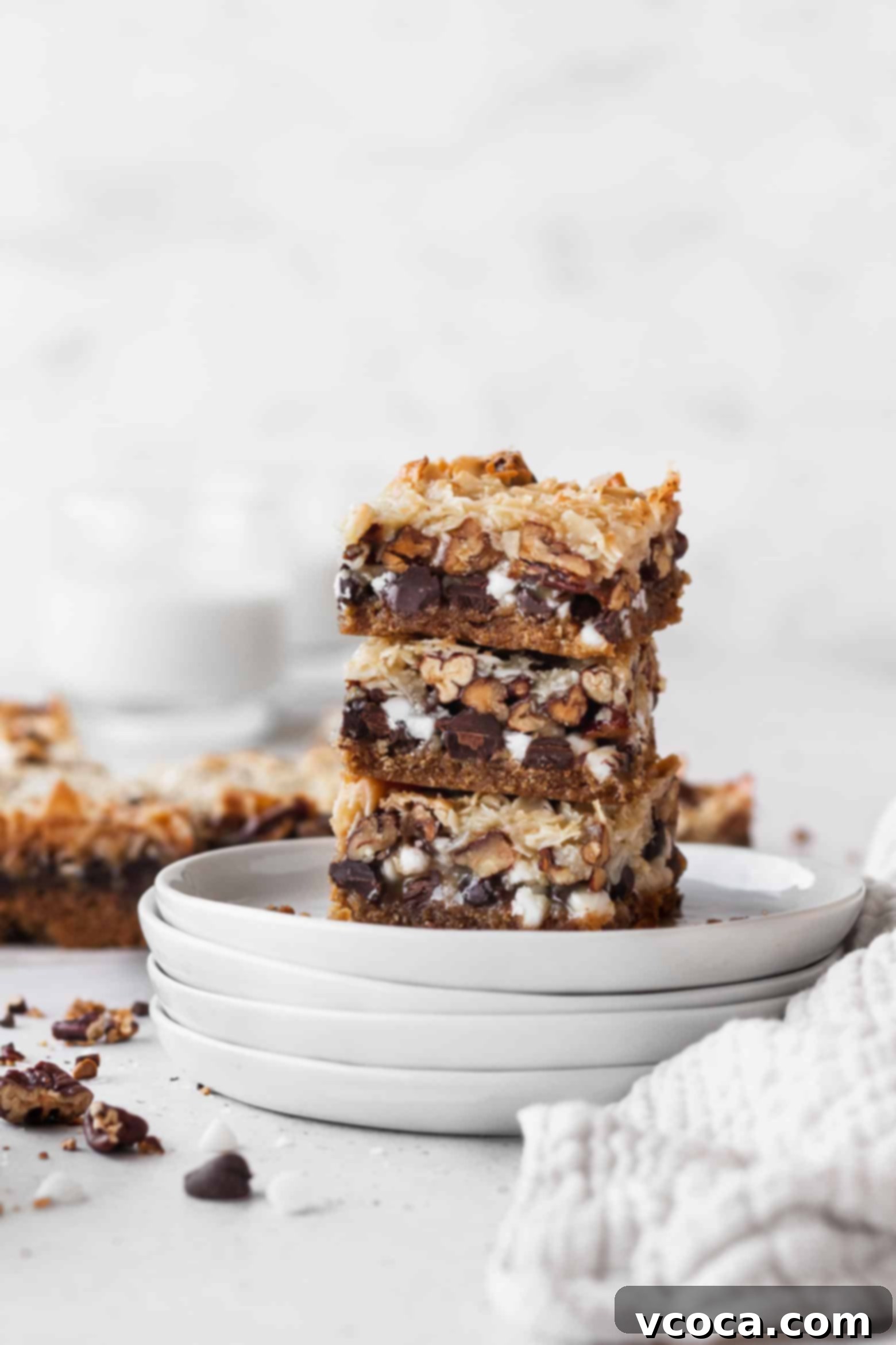 Magical Vegan Seven Layer Bars 2 A stack of vegan magic bars on white plates.
