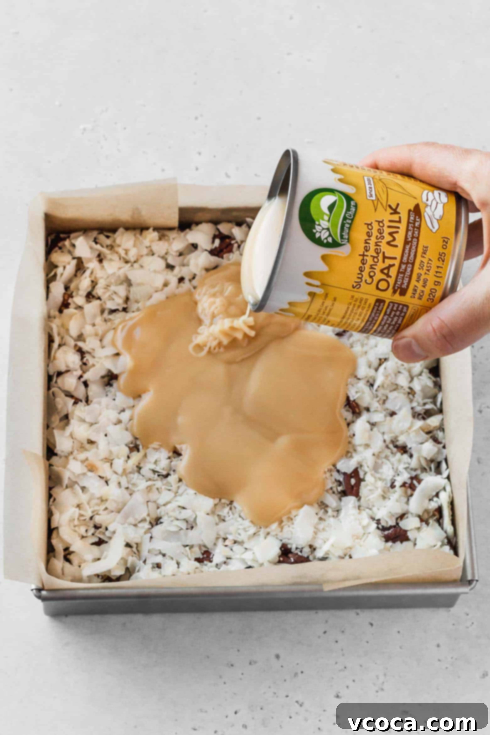 Magical Vegan Seven Layer Bars 13 Pour a can of vegan sweetened condensed milk over the coconut.