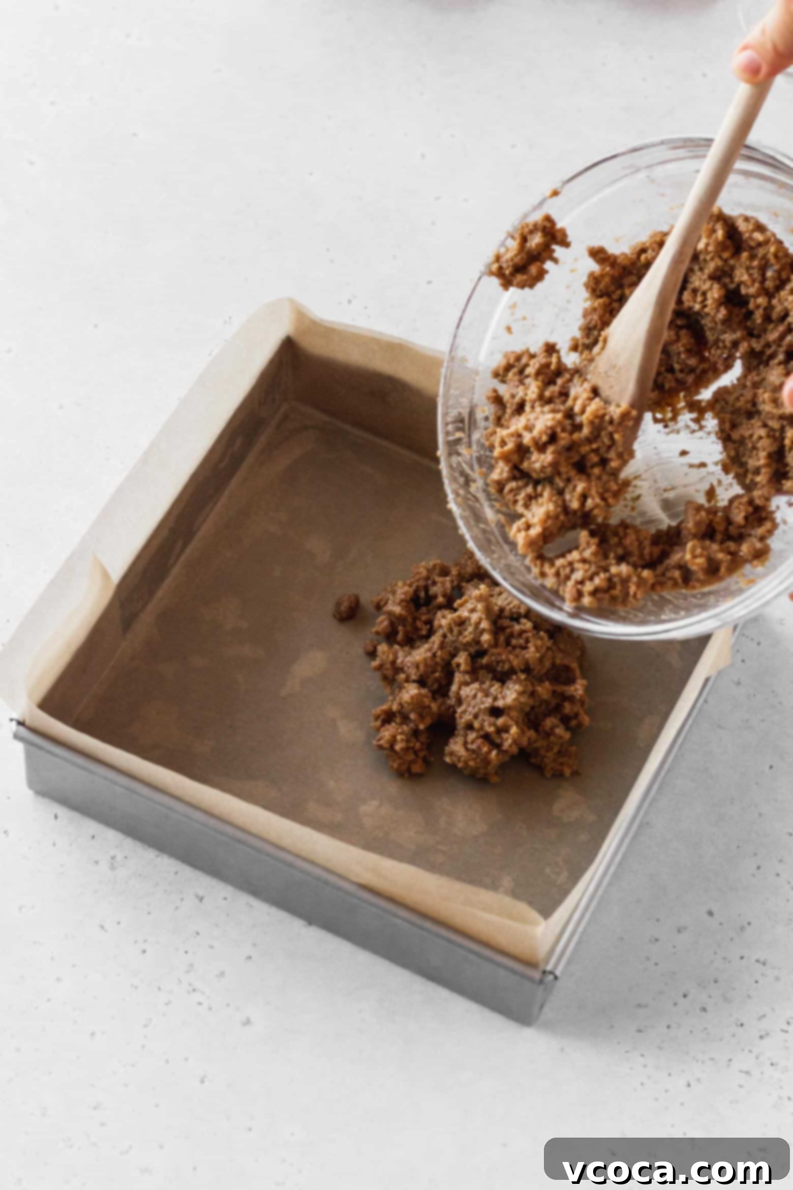 Magical Vegan Seven Layer Bars 9 Putting the graham cracker mixture into a square pan.