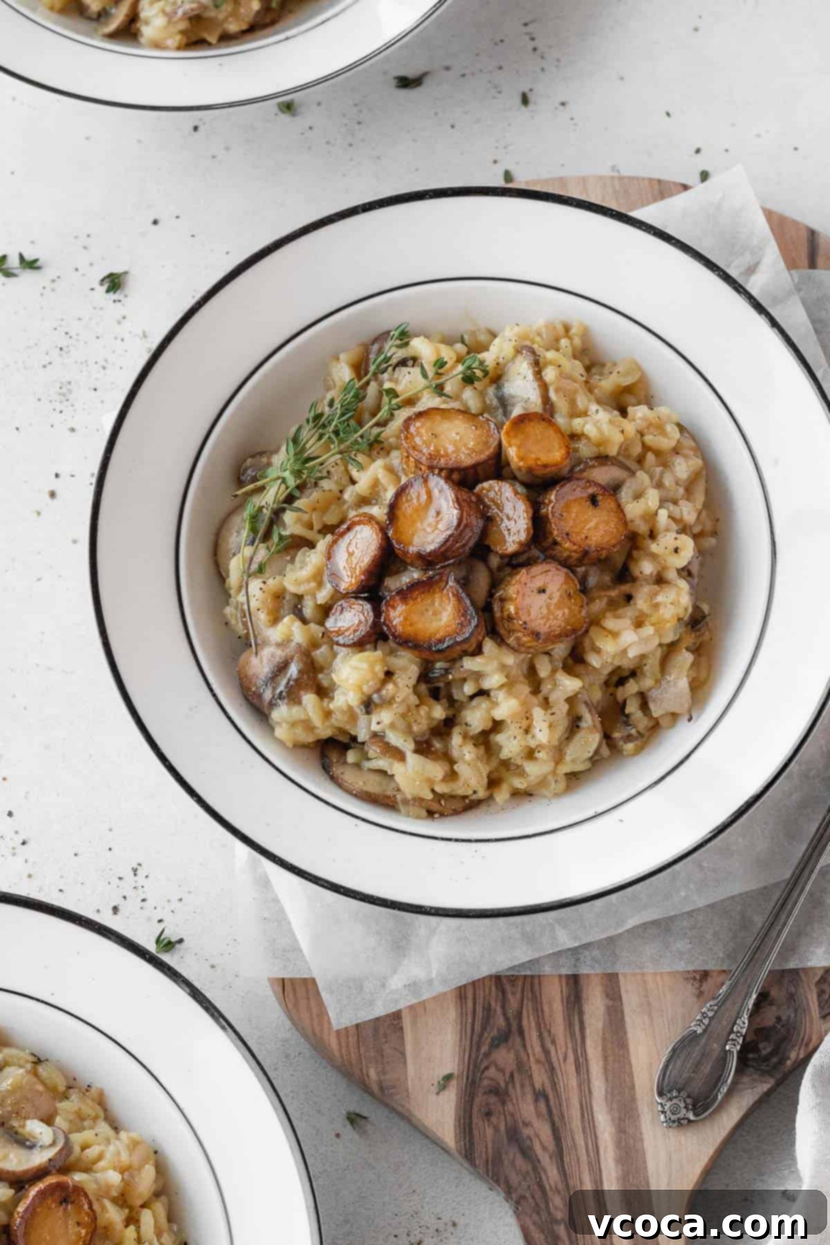 Creamy Vegan Mushroom Risotto 2 A beautifully plated dish of creamy vegan mushroom risotto topped with golden seared vegan scallops and fresh herbs.