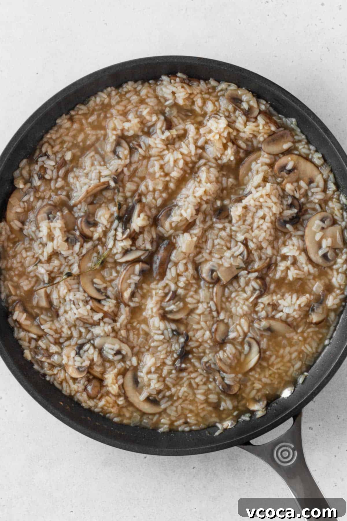 Creamy Vegan Mushroom Risotto 11 The finished creamy vegan mushroom risotto simmering gently in a large black pan, ready for the final touches.