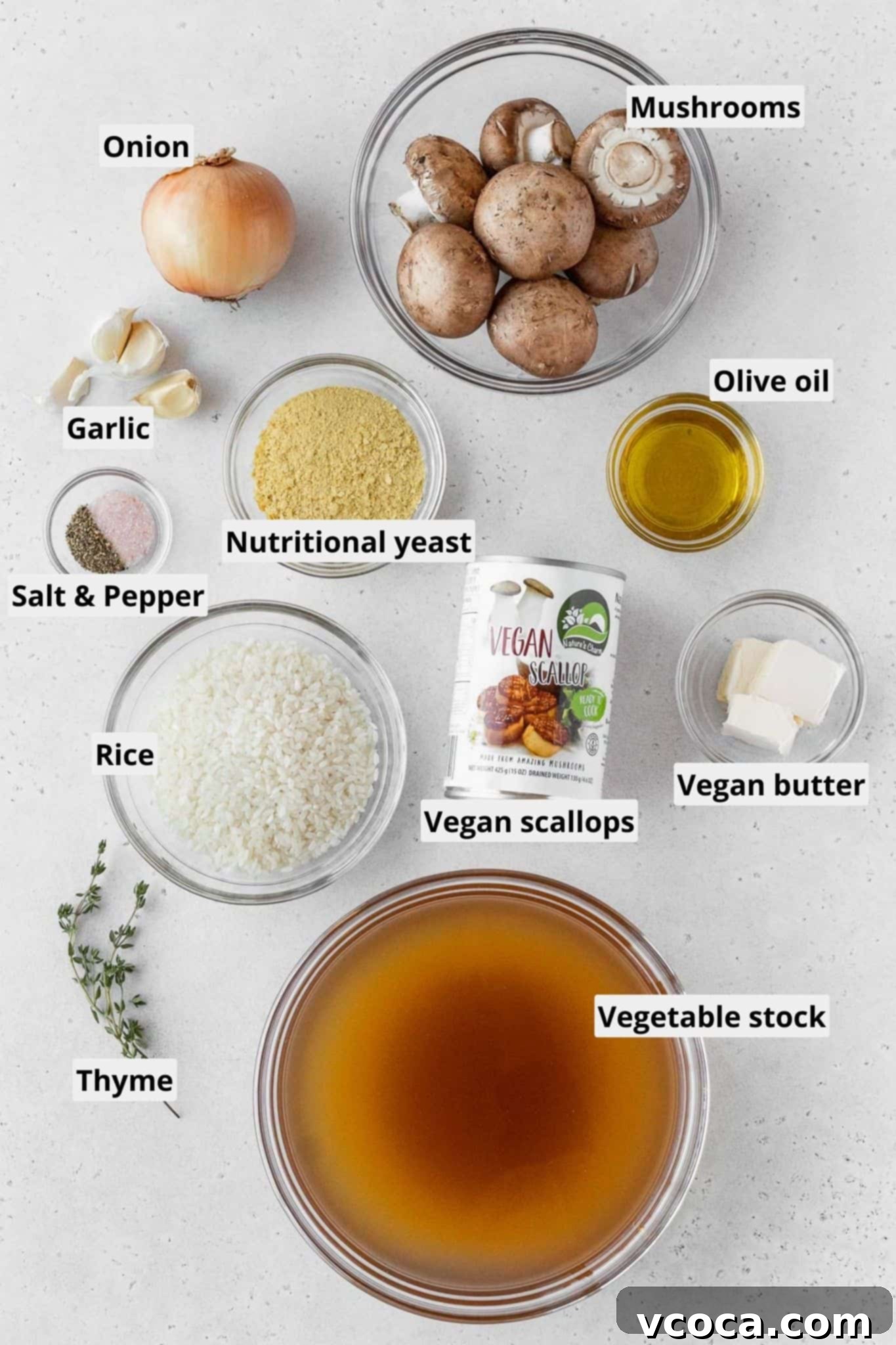 Creamy Vegan Mushroom Risotto 4 A flat lay photograph showcasing all the fresh and canned ingredients for vegan mushroom risotto and vegan scallops, including mushrooms, onion, garlic, rice, stock, and Nature's Charm vegan scallops.