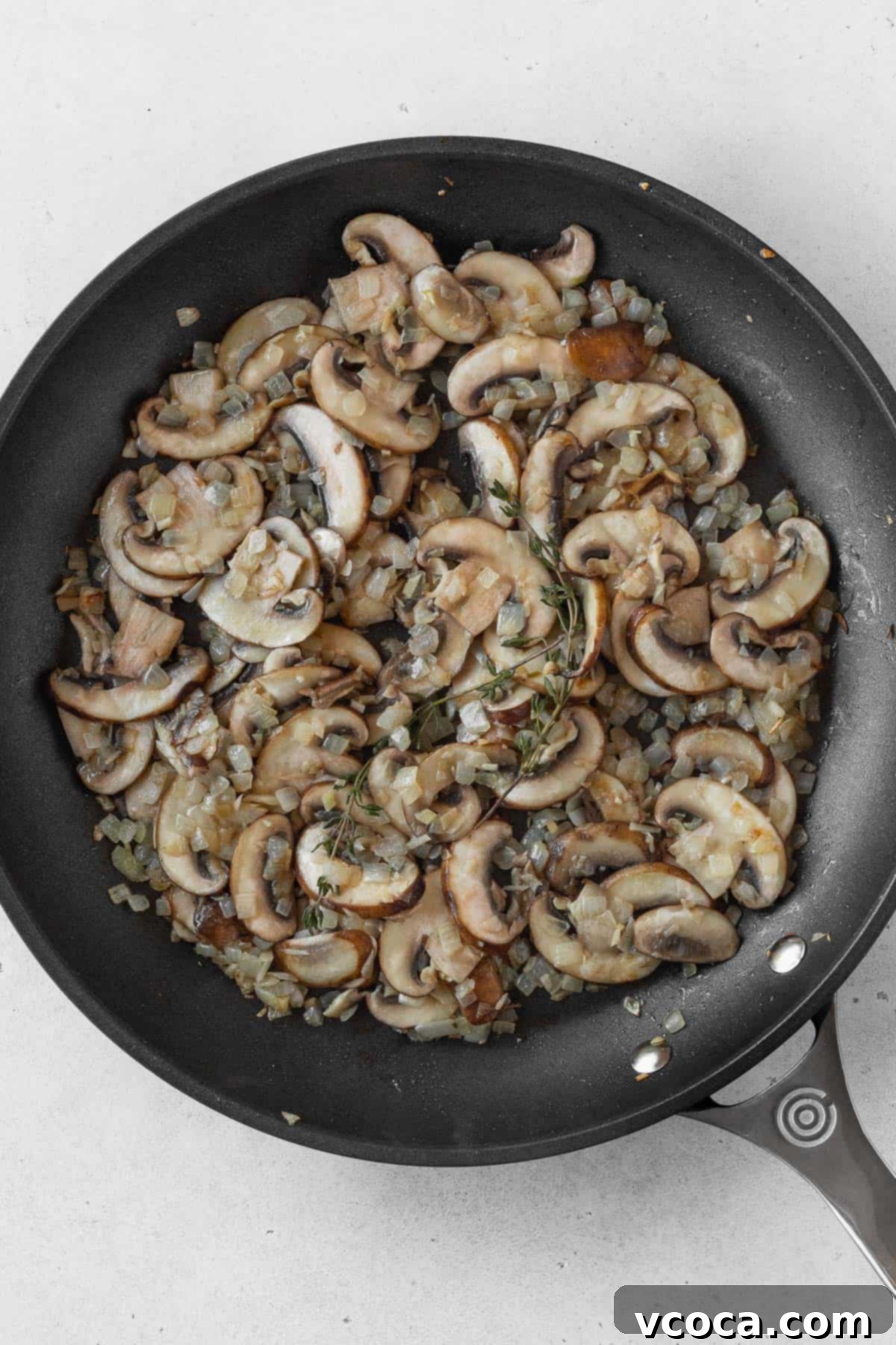 Creamy Vegan Mushroom Risotto 6 Sliced cremini mushrooms and minced garlic added to the translucent onions in the pan, stirring to combine.