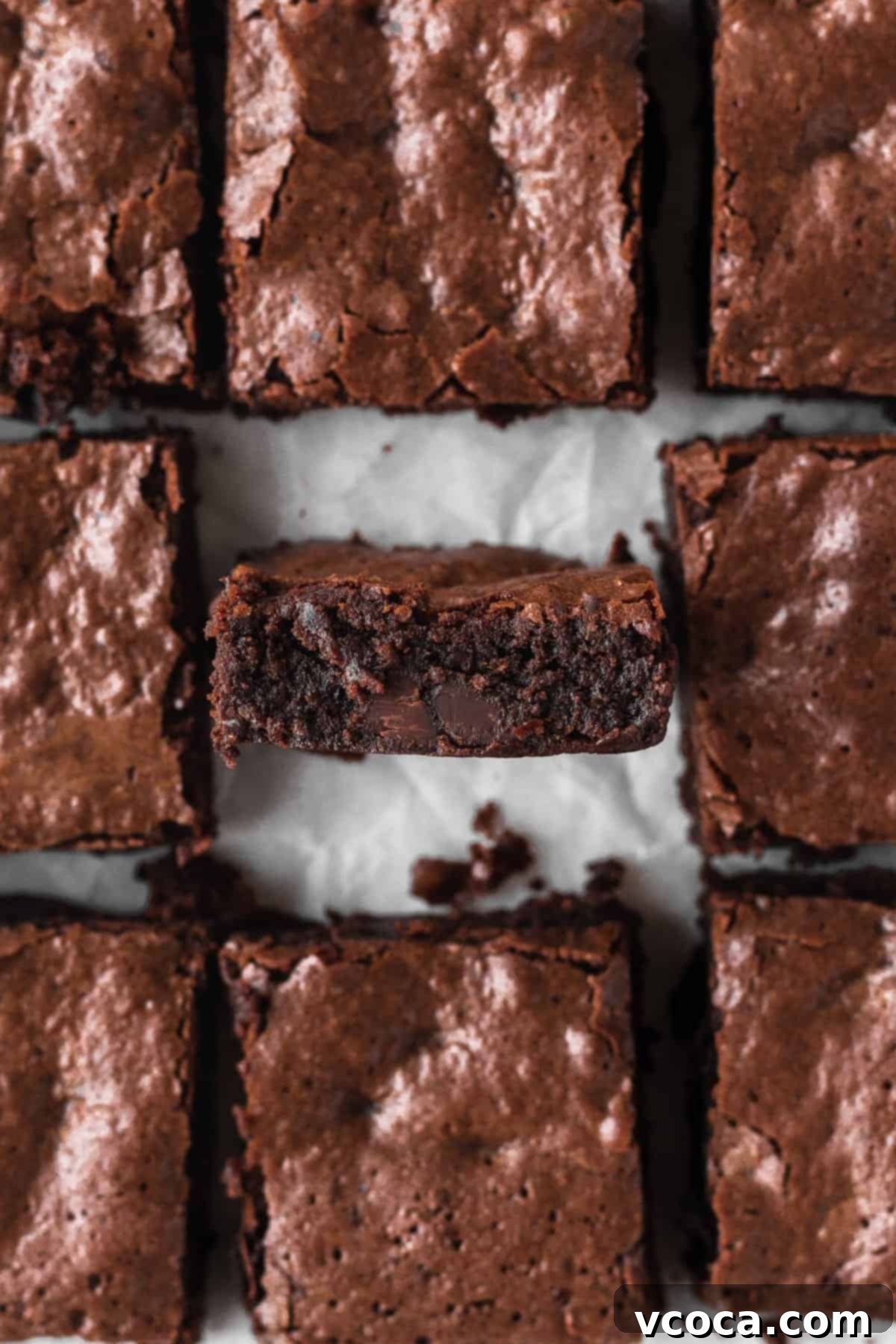 Decadent Gluten-Free Brownies 2 Gluten-free brownies cut into squares with the middle one turned onto its side edge to show the texture. The brownies are dark, rich, and have a beautiful crinkly top.