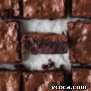Decadent Gluten-Free Brownies 12 A delicious gluten-free brownie with the center piece faced sideways to show its fudgy texture, ready to be enjoyed.