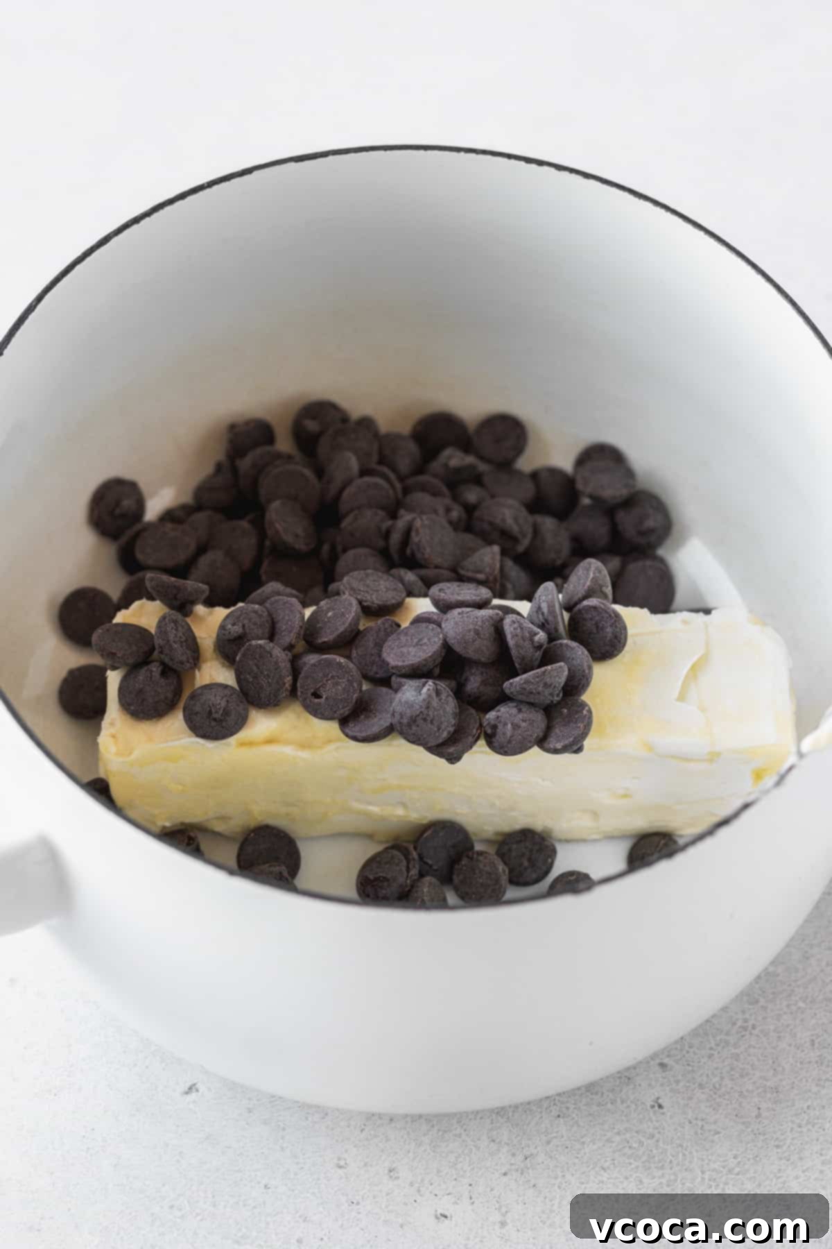 Decadent Gluten-Free Brownies 4 Butter and dark chocolate chips melting together in a white enameled Dutch oven on the stovetop.