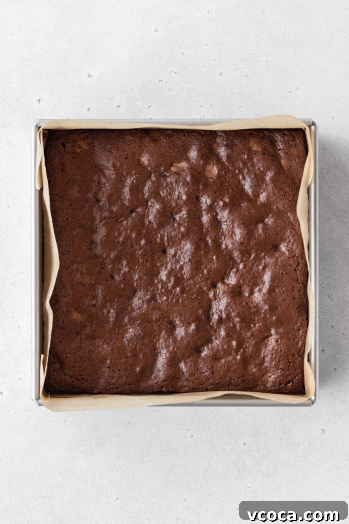 Decadent Gluten-Free Brownies 9 Freshly baked gluten-free brownies still in the square pan, displaying a shiny, crinkly top.