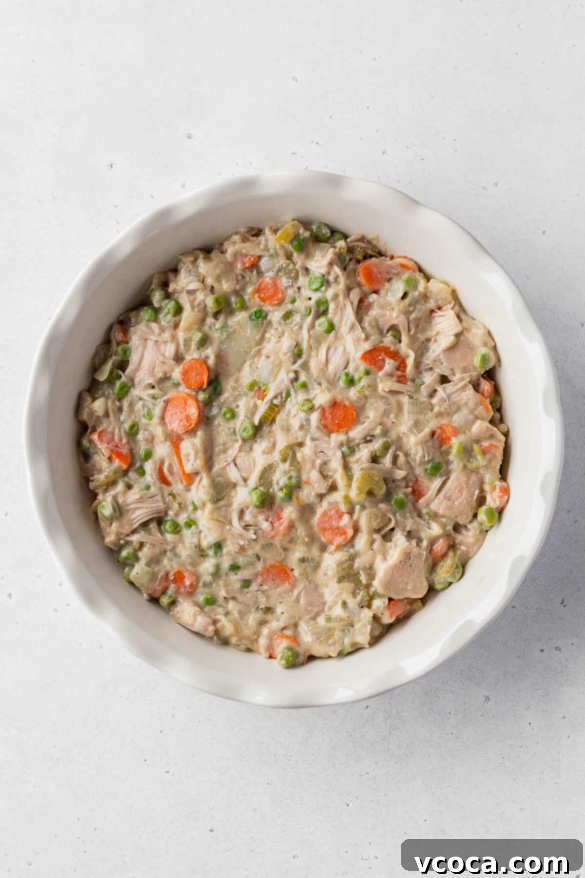 Vegan Chicken Pot Pie 11 An overhead shot of a ceramic pie dish generously filled with creamy vegan pot pie filling, ready for the crust.