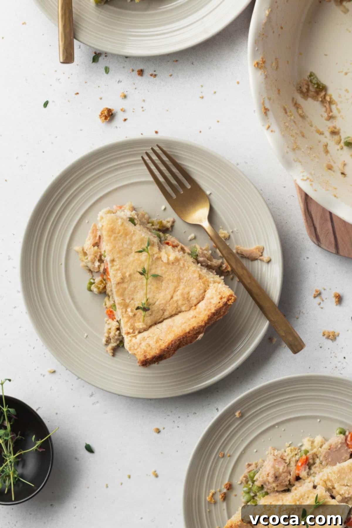 Vegan Chicken Pot Pie 14 Multiple slices of golden-crusted meatless chicken pot pie neatly arranged on white plates, ready to be served.
