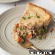 Vegan Chicken Pot Pie 16 A slice of vegan chicken pot pie on a plate with a bite on a gold fork.