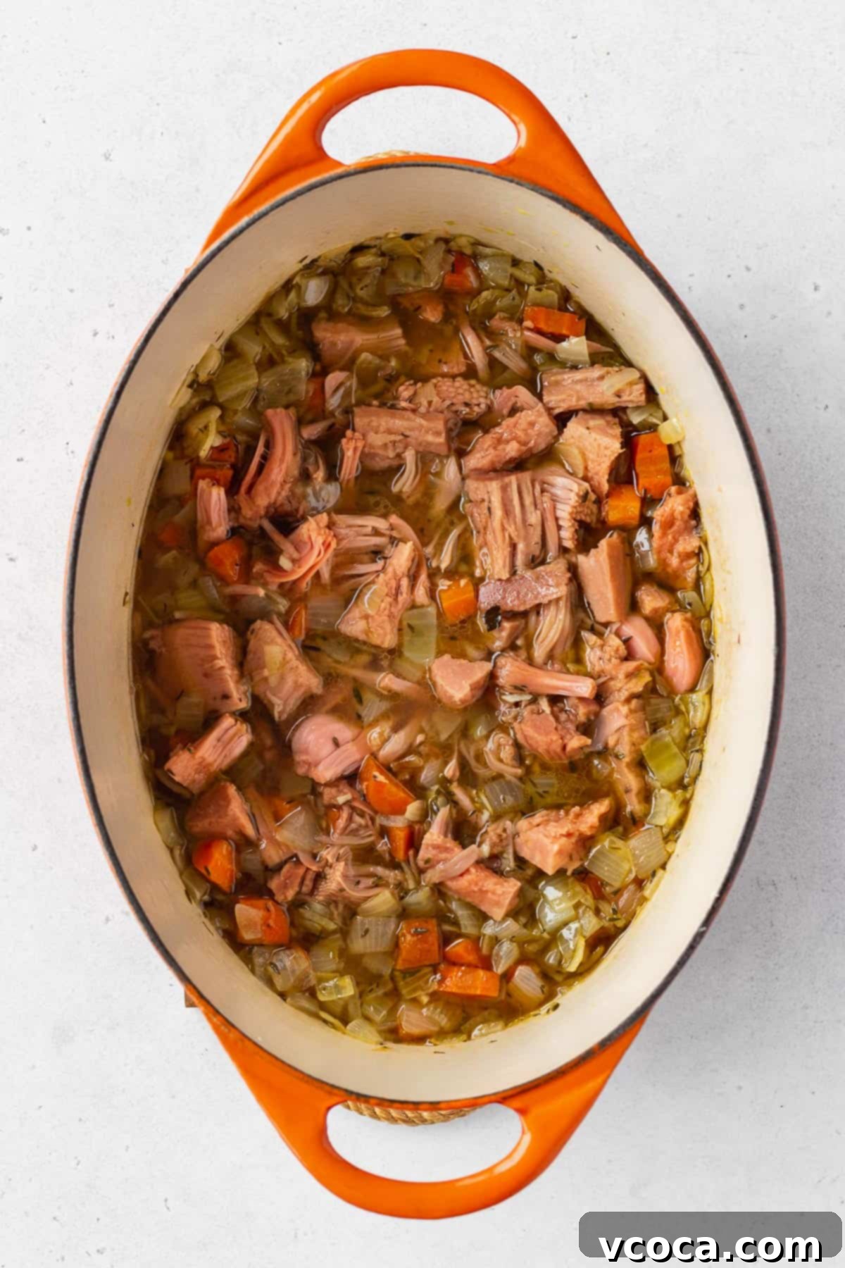 Vegan Chicken Pot Pie 8 An overhead view of a pot containing sautéed vegetables, jackfruit pieces, and vegetable stock simmering together.